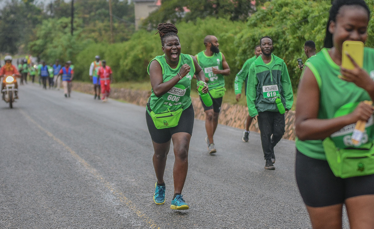 Runner celebrating mid-race, surrounded by fellow runners