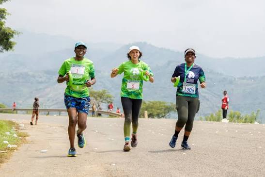 Three runners on a scenic hilly road